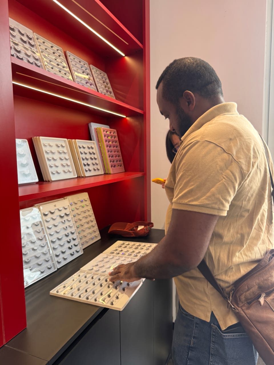 Customer browsing false-lash sample trays at a Daisy Source showroom